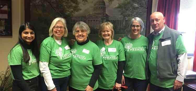 Six people in Sandy Hook Promise shirts standing side by side smiling